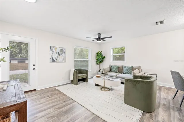 a living room with furniture and a wooden floor