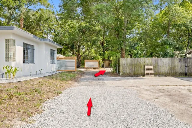 a view of white house with a backyard and tree