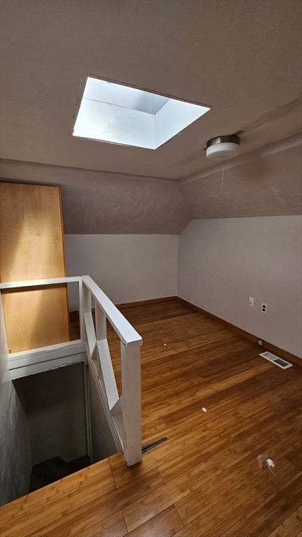 90 Wallace Street, Unit 2 Somerville, MA 02144 - Photo 15 of 17 a view of an empty room with wooden floor and staircase