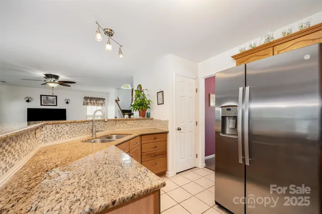a kitchen with stainless steel appliances granite countertop a refrigerator and a sink