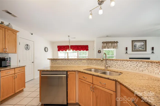 a kitchen with granite countertop a sink stainless steel appliances and cabinets