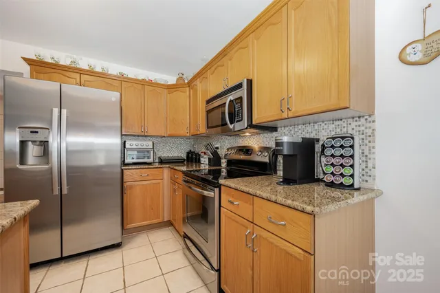 a kitchen with stainless steel appliances granite countertop a refrigerator sink and stove