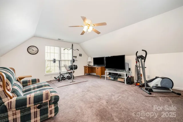 a living room with furniture a flat screen tv and a large window