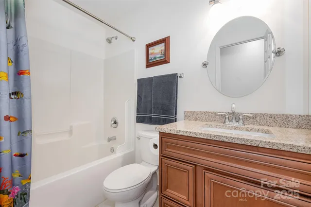 a bathroom with a granite countertop sink a toilet and a bathtub