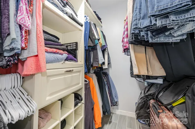 a view of walk in closet with clothes and shoes