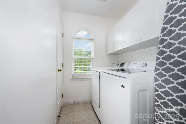 a utility room with cabinets washer and dryer