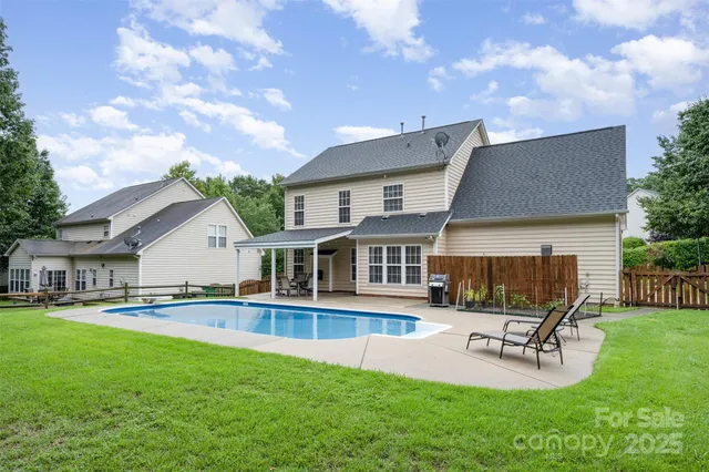 a swimming pool view with a seating space and a yard