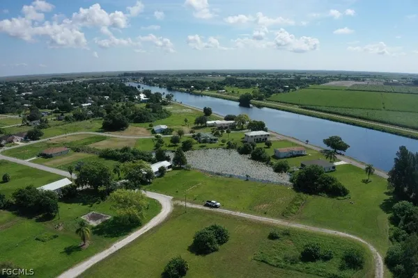 an aerial view of a city with lots of residential buildings ocean and mountain view in back