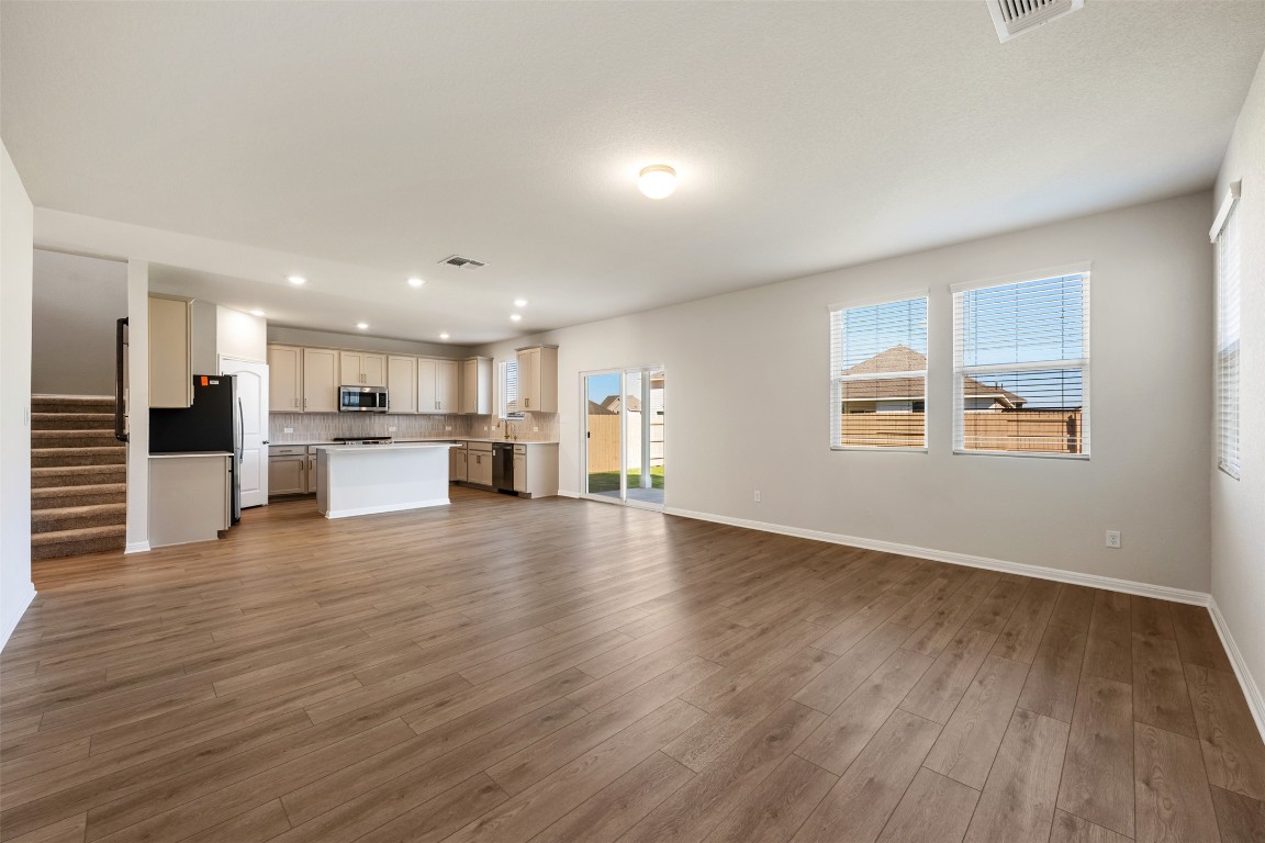 135 Silverleaf Spur Bastrop, TX 78602 - Photo 11 of 40 a view of kitchen with wooden floor and windows