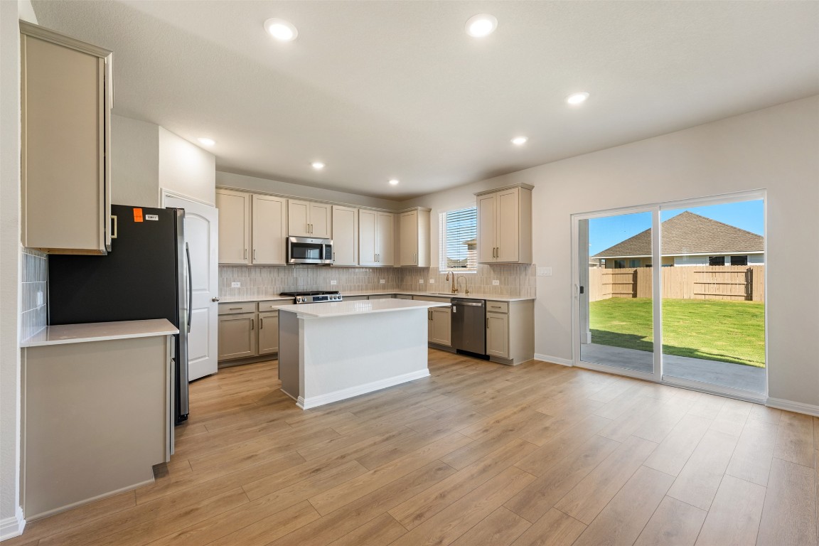 135 Silverleaf Spur Bastrop, TX 78602 - Photo 15 of 40 a kitchen with white cabinets and stainless steel appliances