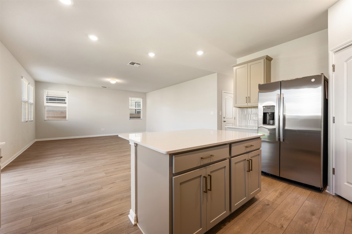 135 Silverleaf Spur Bastrop, TX 78602 - Photo 20 of 40 a kitchen with kitchen island a sink appliances and cabinets