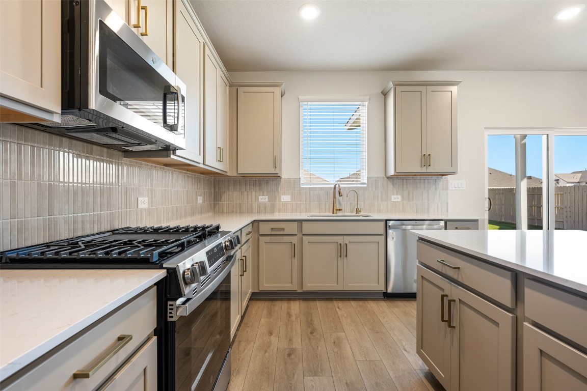135 Silverleaf Spur Bastrop, TX 78602 - Photo 21 of 40 a kitchen with stainless steel appliances granite countertop a sink a stove and cabinets