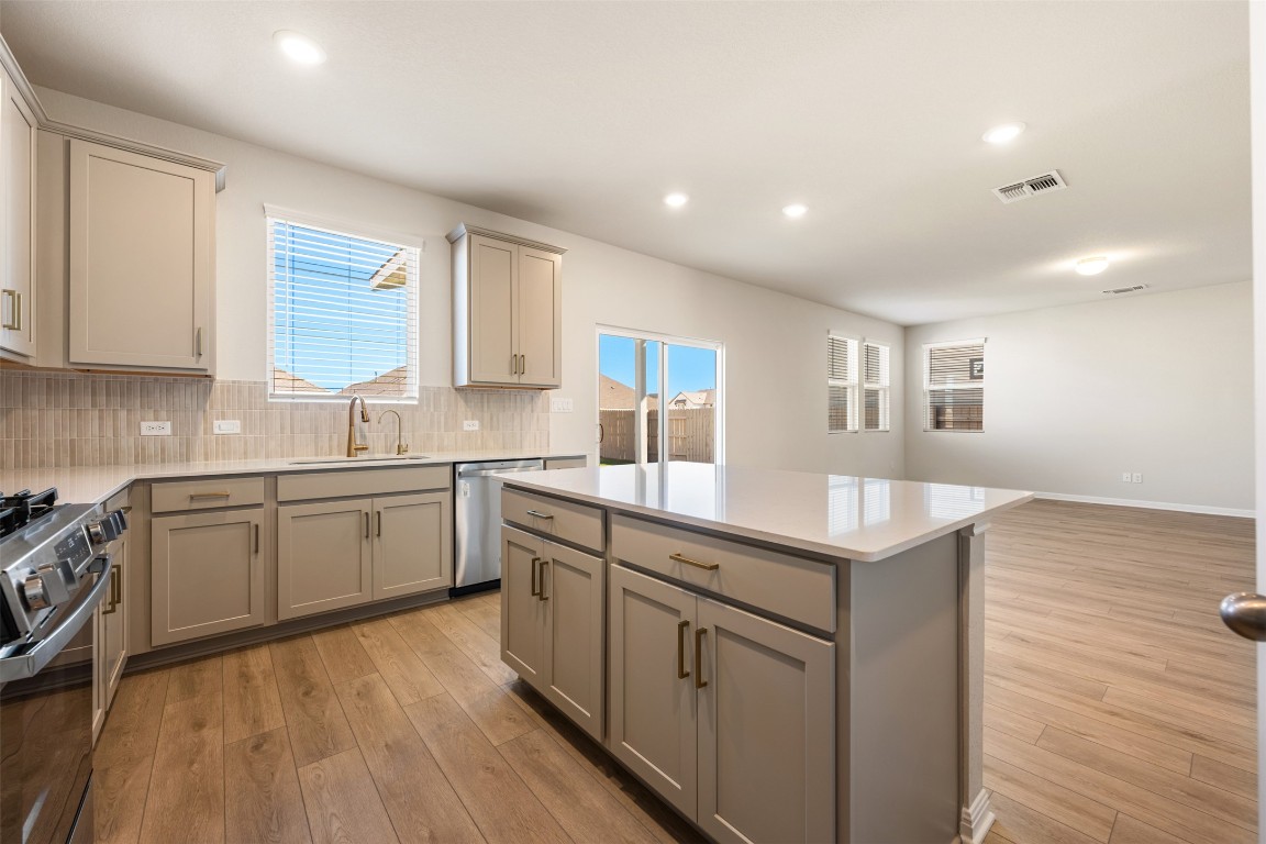 135 Silverleaf Spur Bastrop, TX 78602 - Photo 23 of 40 a kitchen with sink cabinets and wooden floor