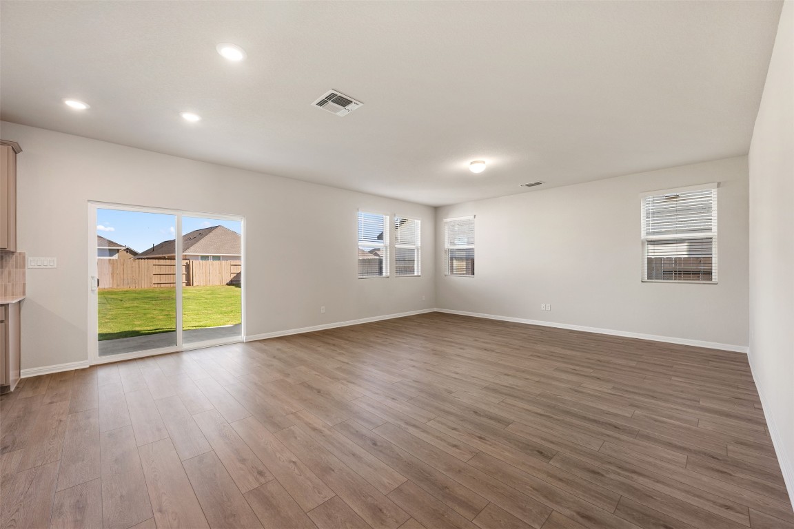 135 Silverleaf Spur Bastrop, TX 78602 - Photo 10 of 40 a view of an empty room with a window and wooden floor