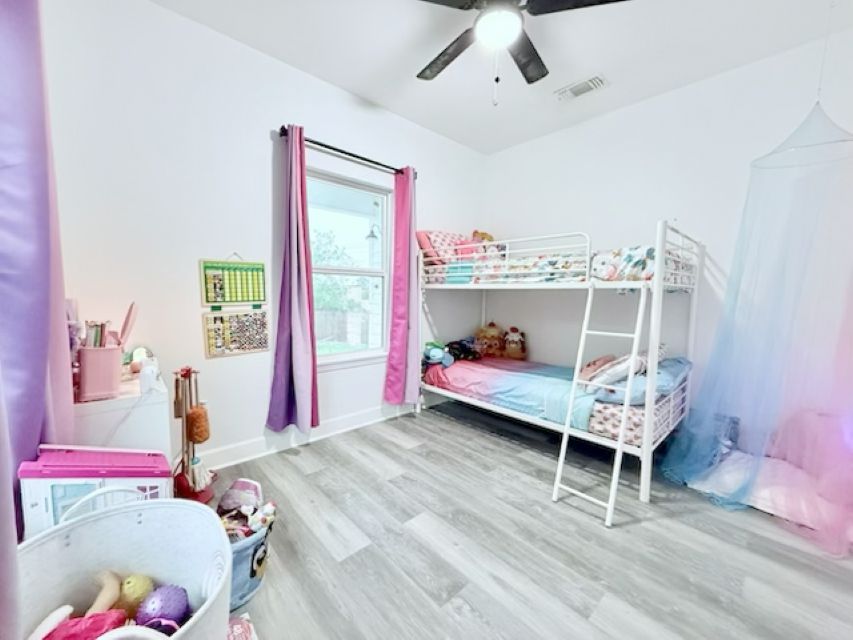 810 Brown Street Brenham, TX 77833 - Photo 26 of 36 a bedroom with a bed and a chandelier