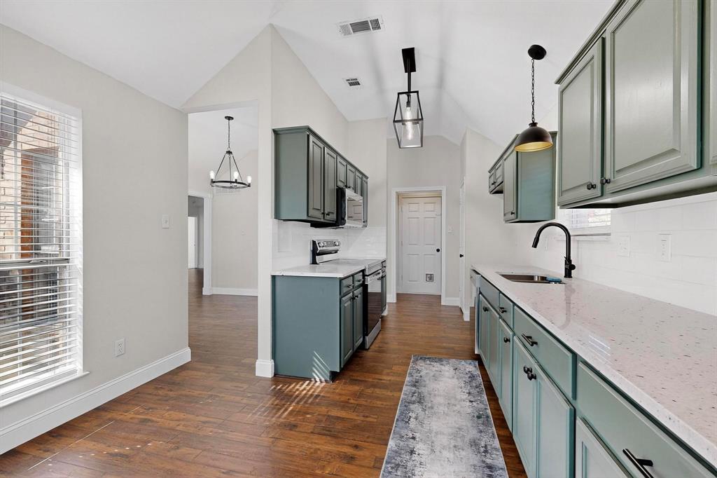 2601 Daisy Lane Rowlett, TX 75089 - Photo 13 of 36 a kitchen with stainless steel appliances a sink stove and wooden floor
