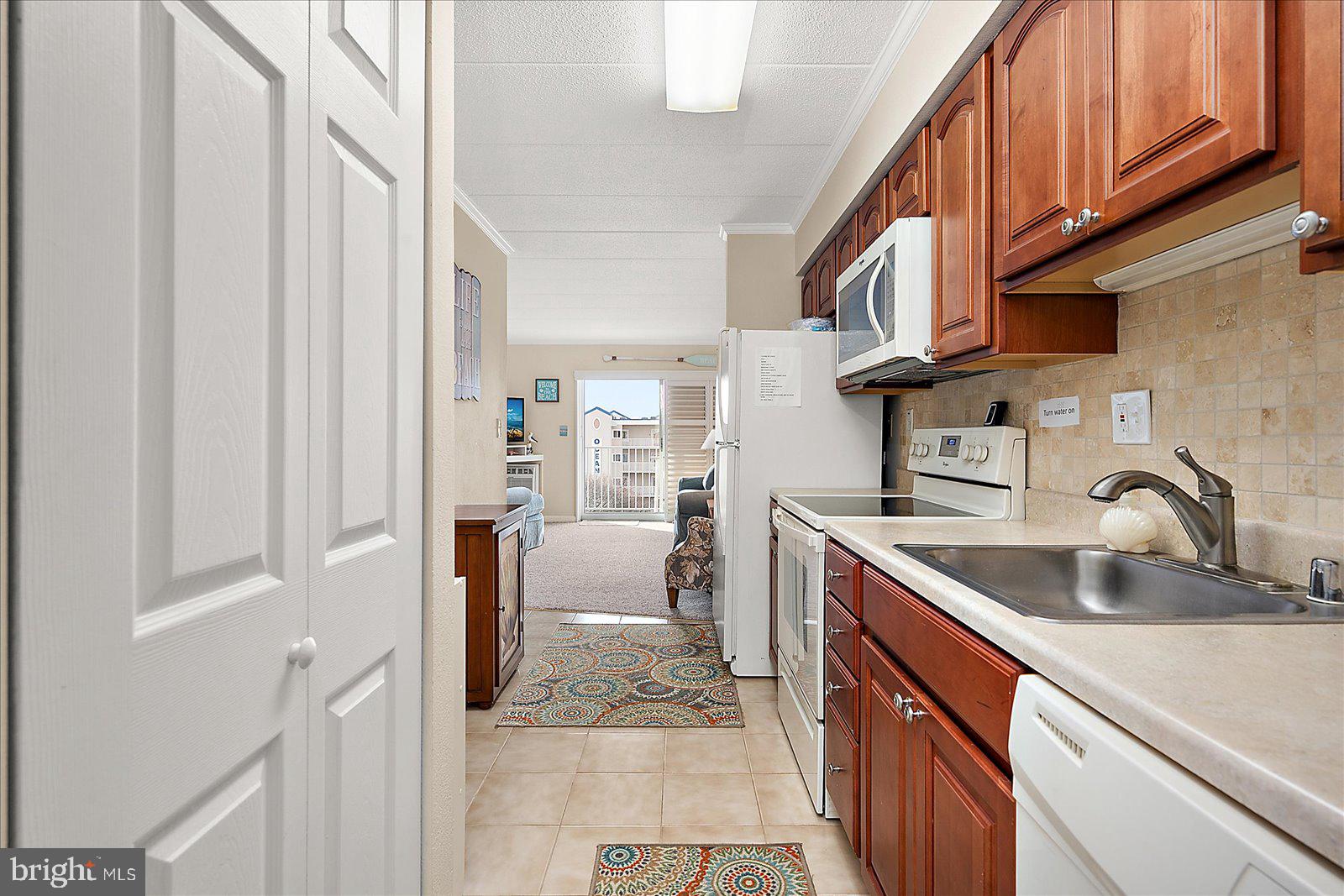 2 80th Street, Unit 504 Ocean City, MD 21842 - Photo 18 of 50 a kitchen with stainless steel appliances granite countertop a sink and dishwasher a refrigerator with wooden cabinets