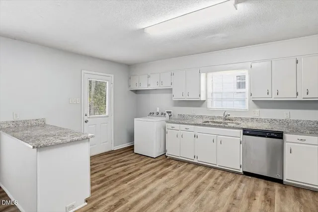 a kitchen with granite countertop cabinets sink and white appliances