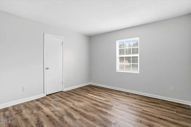a view of an empty room with wooden floor