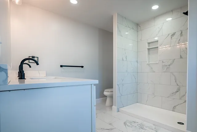 a bathroom with a sink a toilet and shower