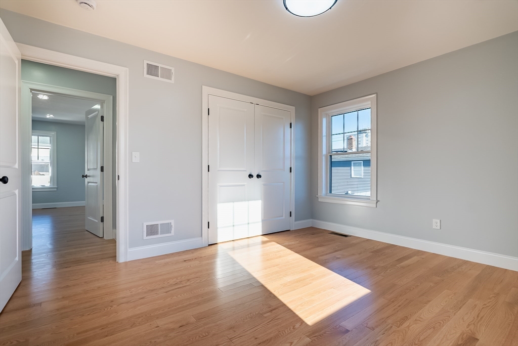 126 Wheeler Street Fall River, MA 02724 - Photo 19 of 32 an empty room with wooden floor and windows