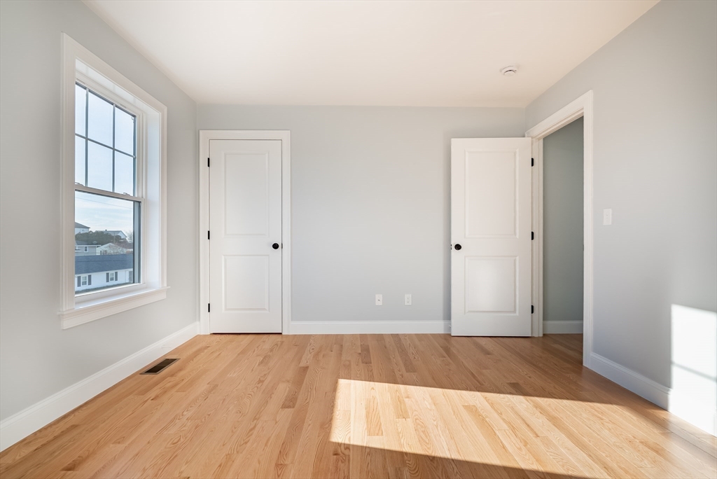 126 Wheeler Street Fall River, MA 02724 - Photo 23 of 32 an empty room with wooden floor and windows