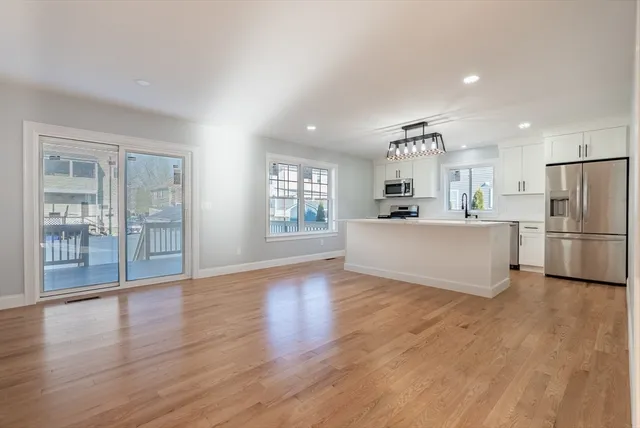 a kitchen with stainless steel appliances a refrigerator and wooden floor