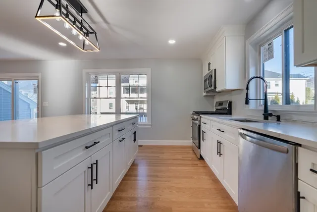 a large kitchen with stainless steel appliances a sink dishwasher a stove and a refrigerator