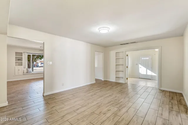 an empty room with a window and a fan