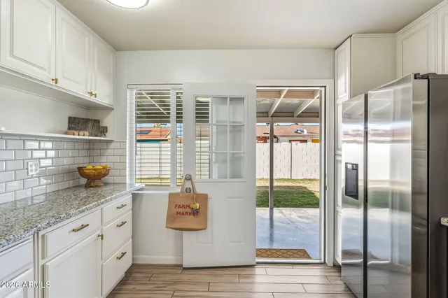 a view of an empty room with a window and a kitchen