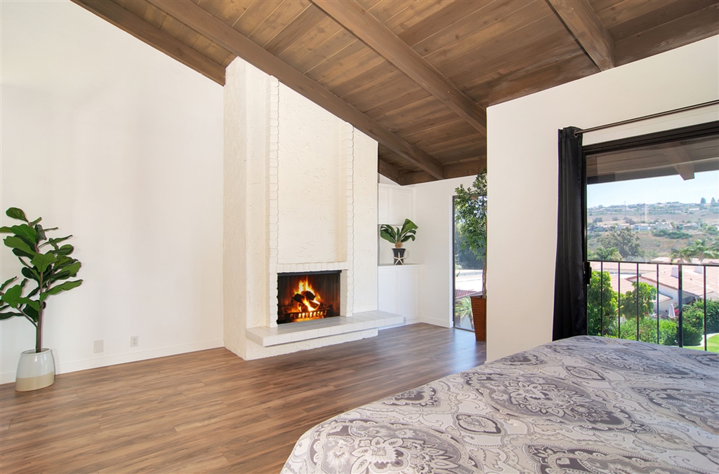 1939 Alga Road, Unit D Carlsbad, CA 92009 - Photo 10 of 25 Master bedroom with fireplace, vaulted wood ceilings and view from windows and deck.