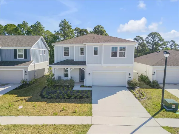 a front view of a house with a yard and a garage