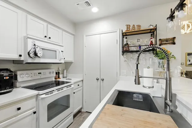 a kitchen with white cabinets and appliances