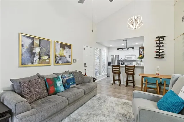 a living room with furniture kitchen view and a window
