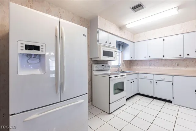 a kitchen with cabinets stainless steel appliances and a refrigerator