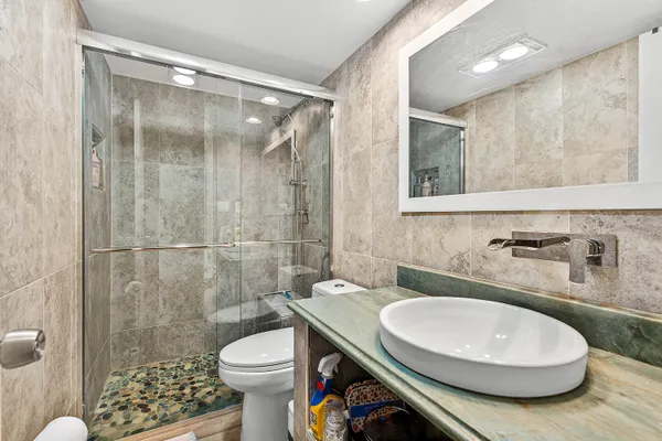 a bathroom with a sink toilet and shower