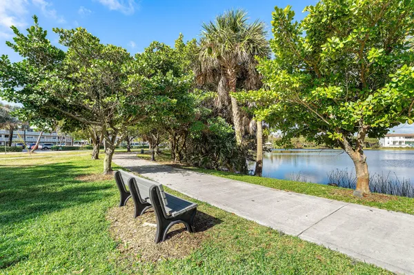 a view of a bench in a garden near a lake