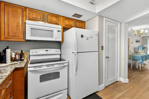 a white refrigerator freezer and a stove sitting inside of a kitchen