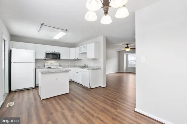 a kitchen with a white cabinets stove and refrigerator