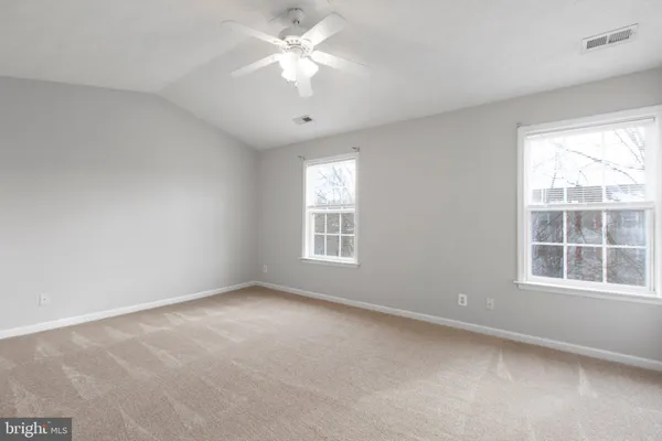 an empty room with a window and a ceiling fan