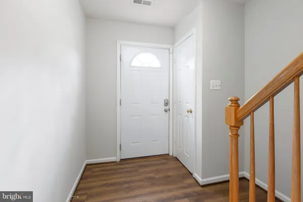 a view of a hallway with wooden floor and staircase