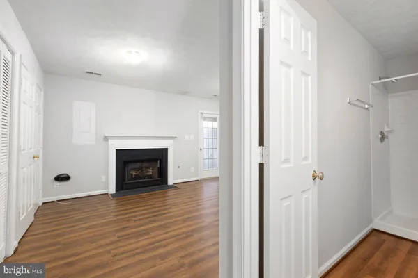 a view of a livingroom with wooden floor and a fireplace