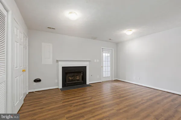 an empty room with wooden floor and fireplace