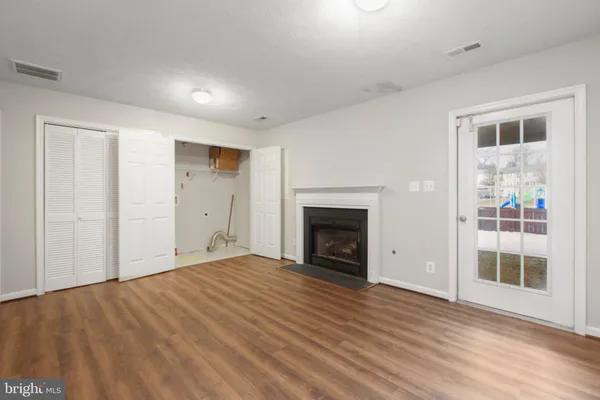 a view of empty room with wooden floor and fireplace