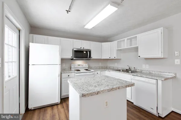 a kitchen with stainless steel appliances granite countertop a refrigerator a sink a stove a microwave and island