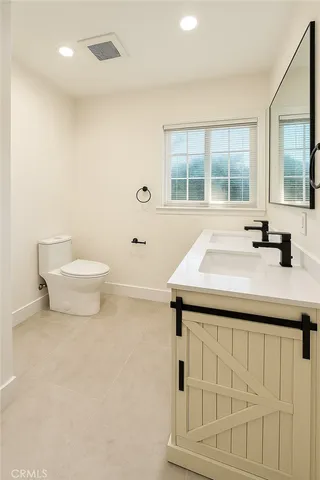 a bathroom with a sink a toilet and a large window