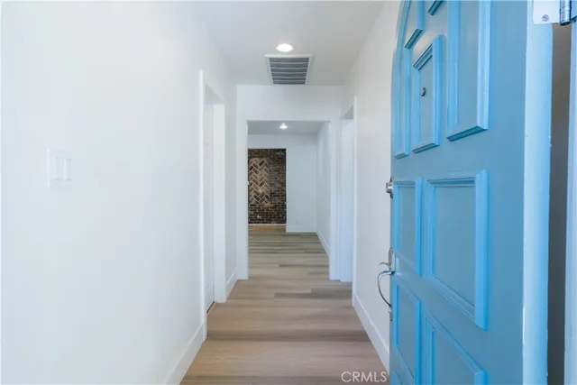 a view of a hallway with wooden floor and entryway