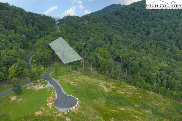 a view of a lake with huge green field and trees