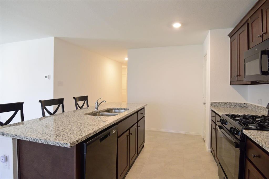 14133 Aberavon Drive Pilot Point, TX 76258 - Photo 5 of 18 a kitchen with granite countertop cabinets and stove