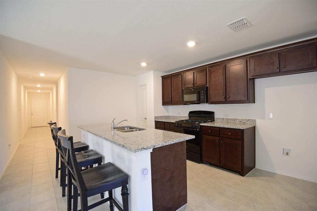 14133 Aberavon Drive Pilot Point, TX 76258 - Photo 7 of 18 a kitchen with a sink cabinets and wooden floor